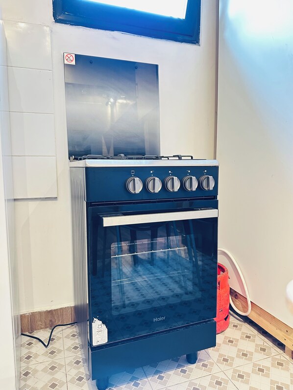 A black Haier oven with four knobs, a glass door, and a window above it.
