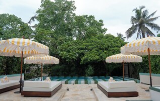 Una piscina al aire libre, camas de piscina gratis, sombrillas