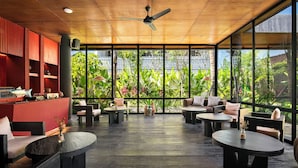 A modern indoor space with a wooden ceiling, large windows, and a variety of seating arrangements. - The Craft Hotel Ubud (Ubud)