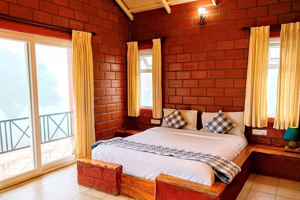 A spacious bedroom with a large bed, wooden headboard, and a balcony view.