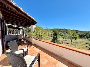 A balcony with outdoor furniture, a view of the countryside, and a clear blue sky. - " Blue Design Apartment " (Tortolì)
