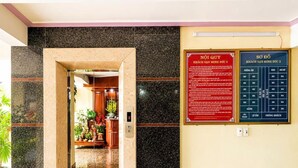 A hotel lobby with a marble floor, a reception desk, and a directory on the wall. - Minh Duc 2 Hotel (Trung Khanh)