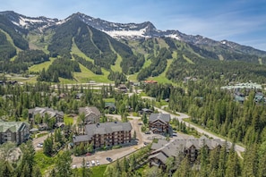 A mountainous resort area with multiple buildings, including a large lodge with a prominent entrance and several smaller structures. - 2 bedroom condo at Timberline's Aspen Lodge (Fernie)