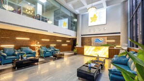 A spacious lobby with a reception desk, seating area with sofas, and a large chandelier. - Regenta Z Sunrise Gachibowli Hyderabad (Hyderabad)