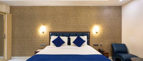A hotel room with a large bed, two bedside tables, a nightstand, a chair, and a small table.
