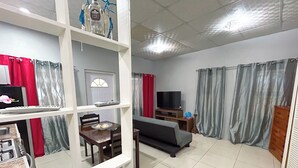 Saló amb sofà, televisió i taula de dinar amb cadires. Hi ha una cuina amb fogó i armaris.