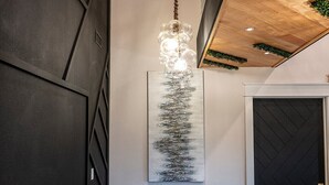 Een modern interieur met een bruine leren bank, een houten eettafel en een hanglamp.