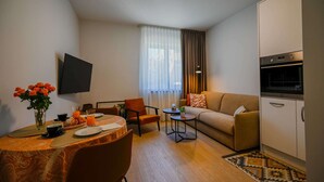 A compact living space with a dining area, a sofa, a TV mounted on the wall, and a kitchenette. - Modern and Stylish Apartment With Terrace (Rovinj)
