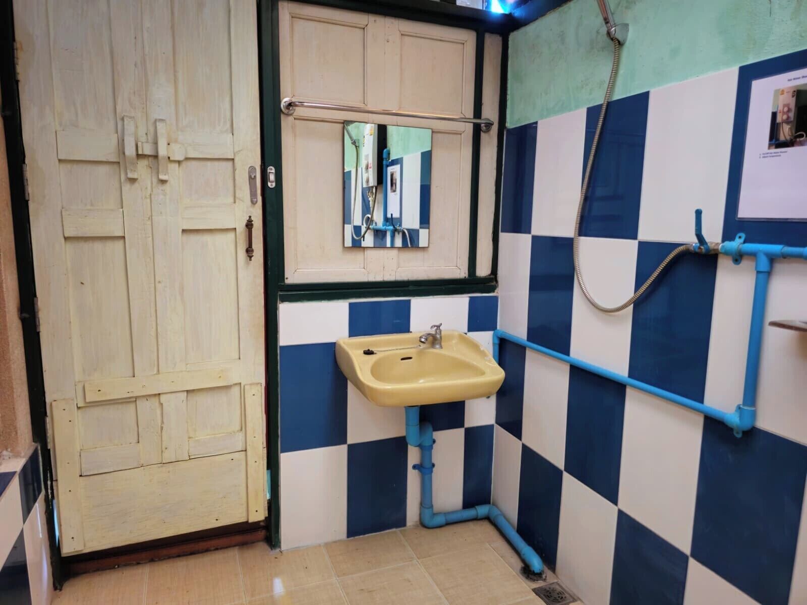 A small bathroom with a sink, mirror, and blue and white checkered walls.