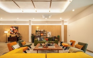 A modern living room with a central coffee table, sofas, and a bookshelf. - Adelphi Itsaraphap (Bangkok)