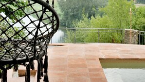 A wicker swing chair overlooking a scenic landscape with a view of hills and a body of water. - Villa delle Colline Lucchesi (Lucca)