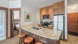 Una cocina moderna con armarios de madera, electrodomésticos de acero inoxidable y encimera de granito.