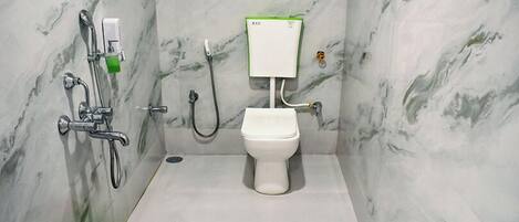 A bathroom with a toilet, a shower, and a bidet.