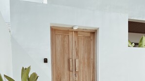 A wooden door with a small step leading up to it, set against a white wall. - Villa Indah (Ungasan)