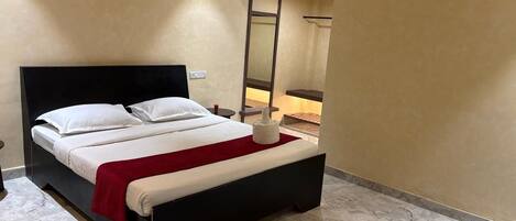 A modern hotel room with a large bed, a red throw blanket, and a marble floor.
