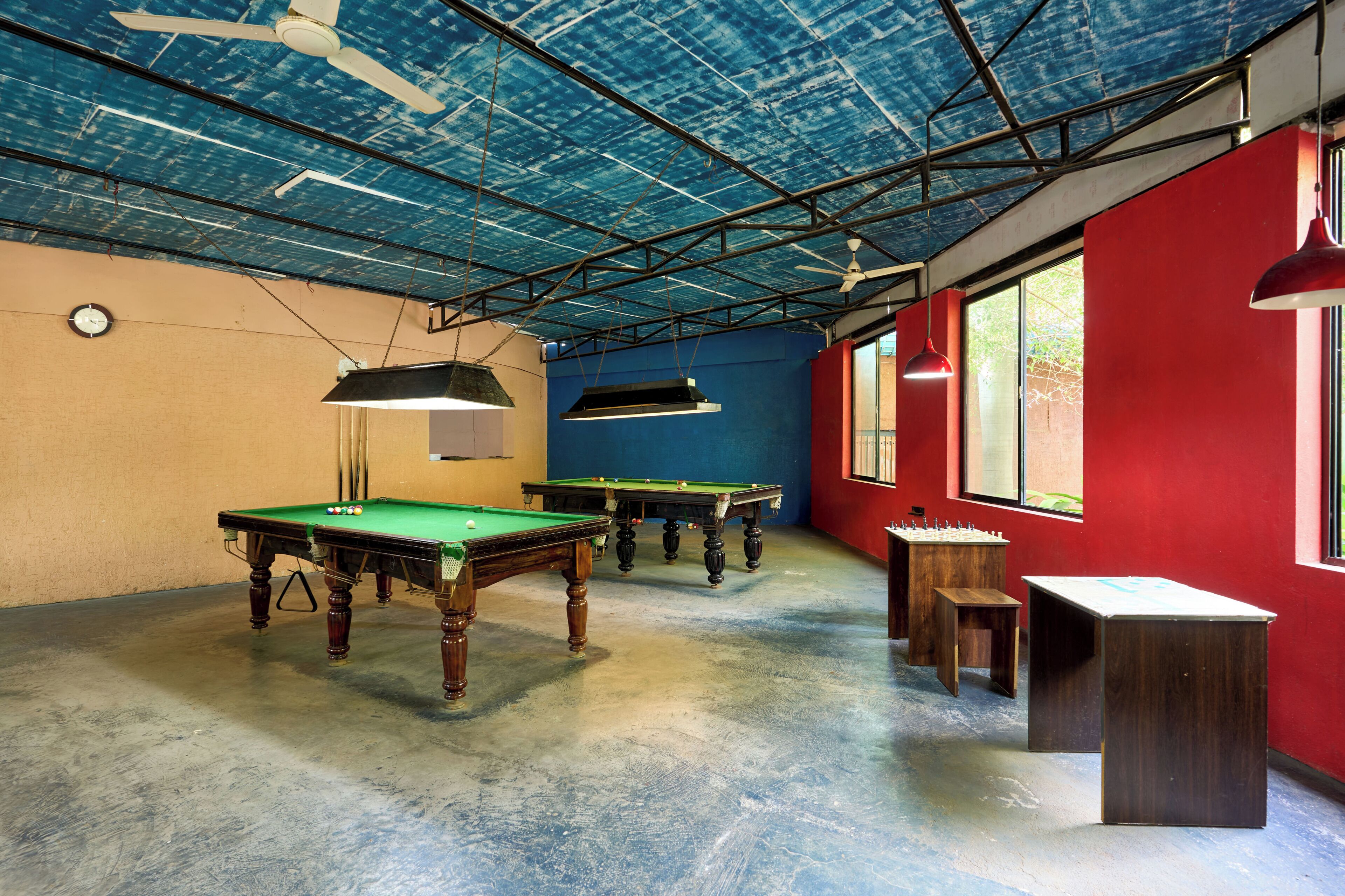 Una stanza con tavolo da biliardo, tavolo da snooker e tavolo da calcio.