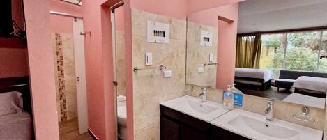 Ein Badezimmer mit rosa Wänden, einem Oberlicht, einer Dusche und einem Waschtisch mit zwei Becken.