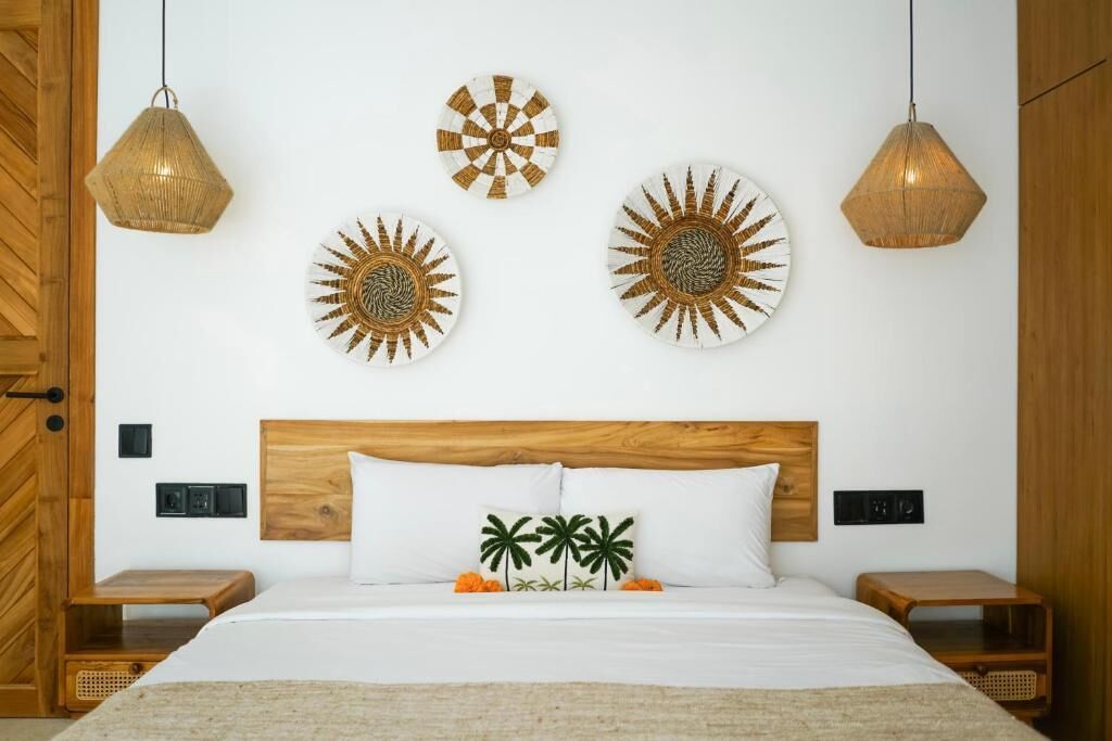 Ein Schlafzimmer mit einem hölzernen Kopfteil, einem Bett mit weißer Bettwäsche, zwei Nachttischen und drei Wandlampen.