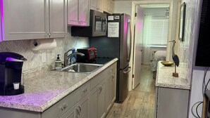 A compact kitchen with grey cabinets, a stainless steel refrigerator, a coffee maker, and a sink. - Stay Where You Play at Paradise Lakes! Sleeps up to 4! (Lutz)