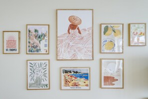 A wall with eight framed artworks depicting various scenes and subjects. - The Boheme - Chic Family Haven -by Mon Petit Faré (Paris)