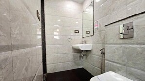 A bathroom with a white toilet, a sink, and a mirror. - The Platinum saltlake (Bidhannagar)