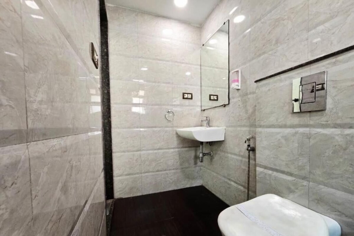 A bathroom with a white toilet, a sink, and a mirror.