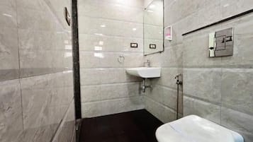 A bathroom with a white toilet, a sink, and a mirror.