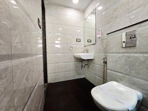 A bathroom with a white toilet, a sink, and a mirror. - The Platinum saltlake (Bidhannagar)