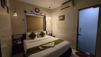 A bedroom with a bed, a ceiling fan, a door, and a wall-mounted air conditioner.