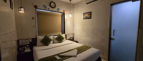 A bedroom with a bed, a ceiling fan, a door, and a wall-mounted air conditioner.
