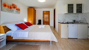 Une chambre d  ’hôtel comprenant un lit, une petite kitchenette et une salle de bain.