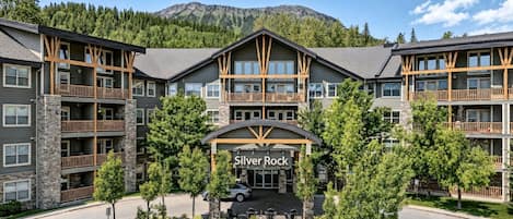 A multi-story hotel with a stone facade, balconies, and a sign reading 'Silver Rock'.