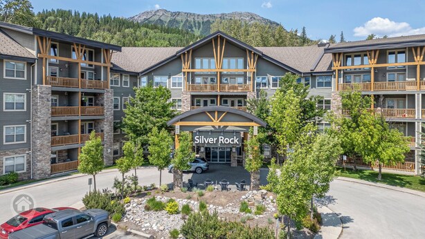 A multi-story hotel with a stone facade, wooden balconies, and a sign reading "Silver Rock".
