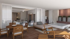 Ein modernes Wohnzimmer mit Essbereich, einer Sofagarnitur, einem kleinen Tisch und einer integrierten Whirlwanne.