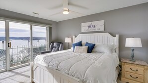 A bedroom with a large bed, a view of the lake, and a ceiling fan. - ‘Harbour Horizon’ Gem: 1 MM Main Channel, 2 Pools (Lake Ozark)