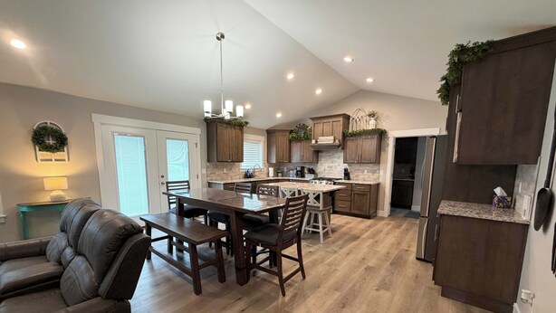 A spacious kitchen with wooden cabinets, a dining area with a table and chairs, and a built-in island.