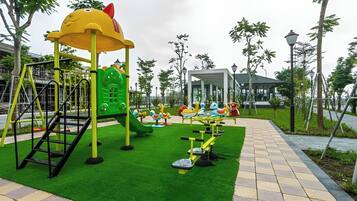 Un parque infantil con tobogán, estructuras para escalar y equipo de ejercicio.
