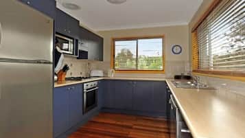 A kitchen with a microwave, stove, and sink.