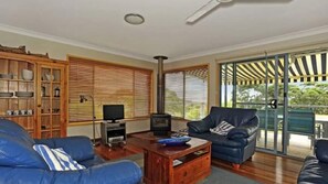 A living room with a sofa, a television, and a fireplace. - Lagava is near Washerwomans Beach (Bendalong)