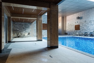 Una piscina techada, sillones reclinables de piscina