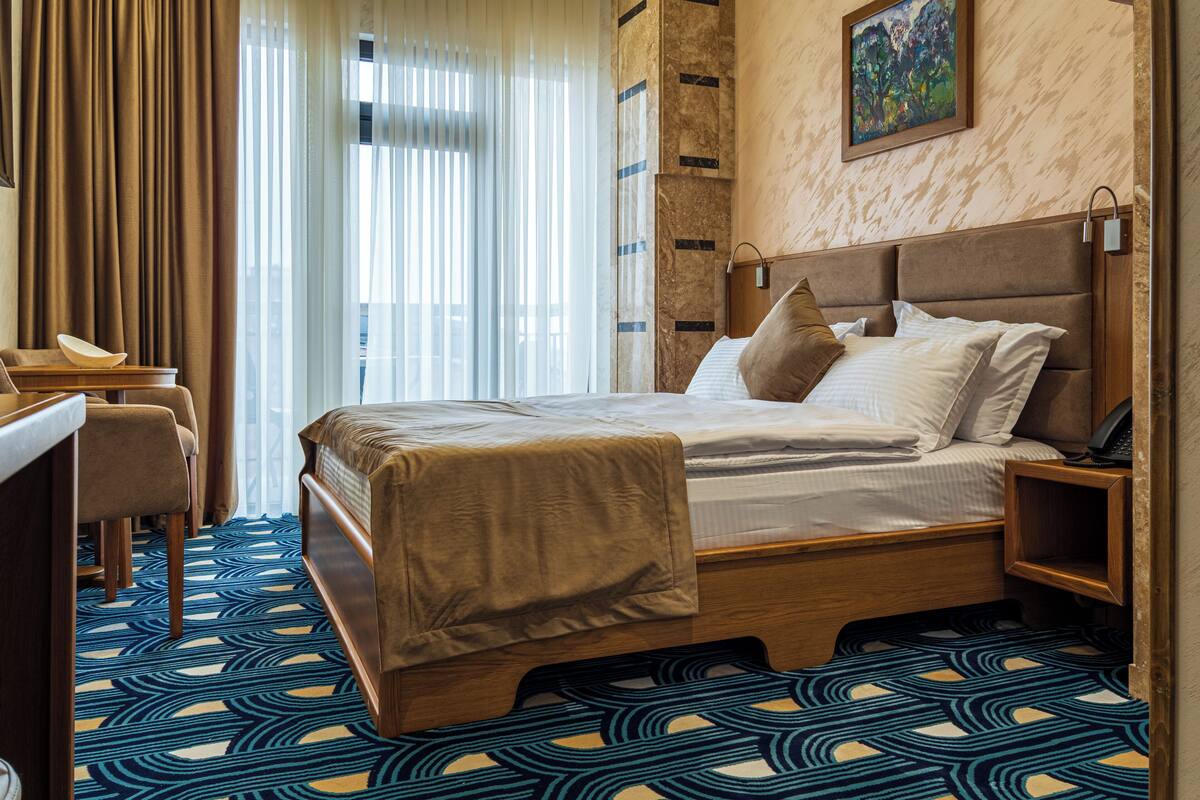 Une chambre d’hôtel avec un lit, un bureau et une chaise.