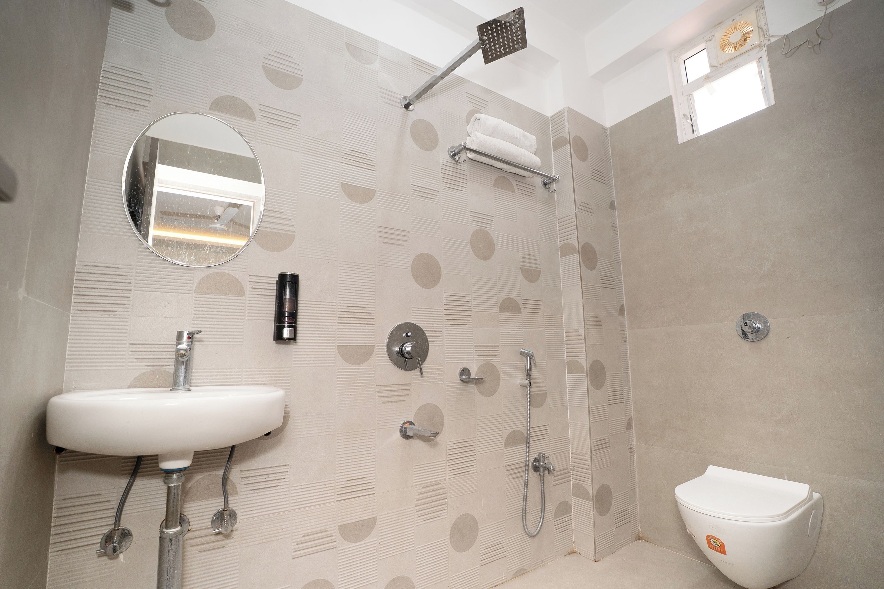 A bathroom with a sink, mirror, towel rack, shower, and toilet.