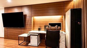 A modern hotel room with a flat-screen TV mounted on the wall, a compact kitchenette, a seating area with a chair, and a refrigerator. - M Place Hotel Guwol-dong (Incheon)
