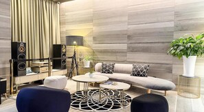 A modern living room with a sofa, two armchairs, a coffee table, and a lamp. There are speakers and a plant in the room. - M Place Hotel Guwol-dong (Incheon)
