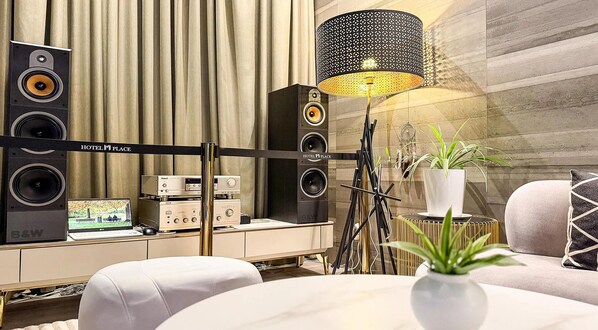 A modern hotel room with a music system, a desk with a computer, and a comfortable seating area. - M Place Hotel Guwol-dong (Incheon)