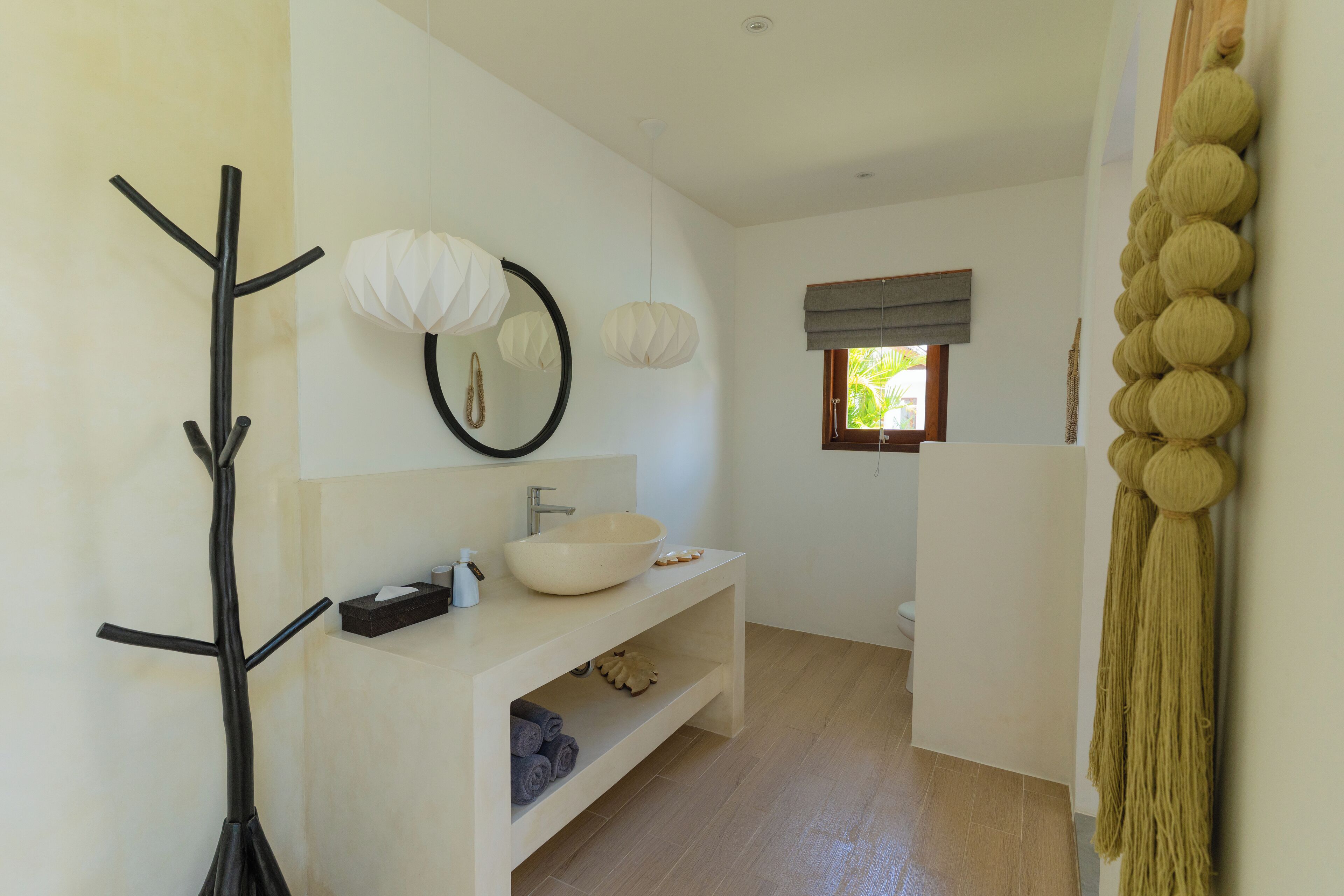 Une salle de bain moderne avec un lavabo blanc, un miroir et un porte-serviettes.