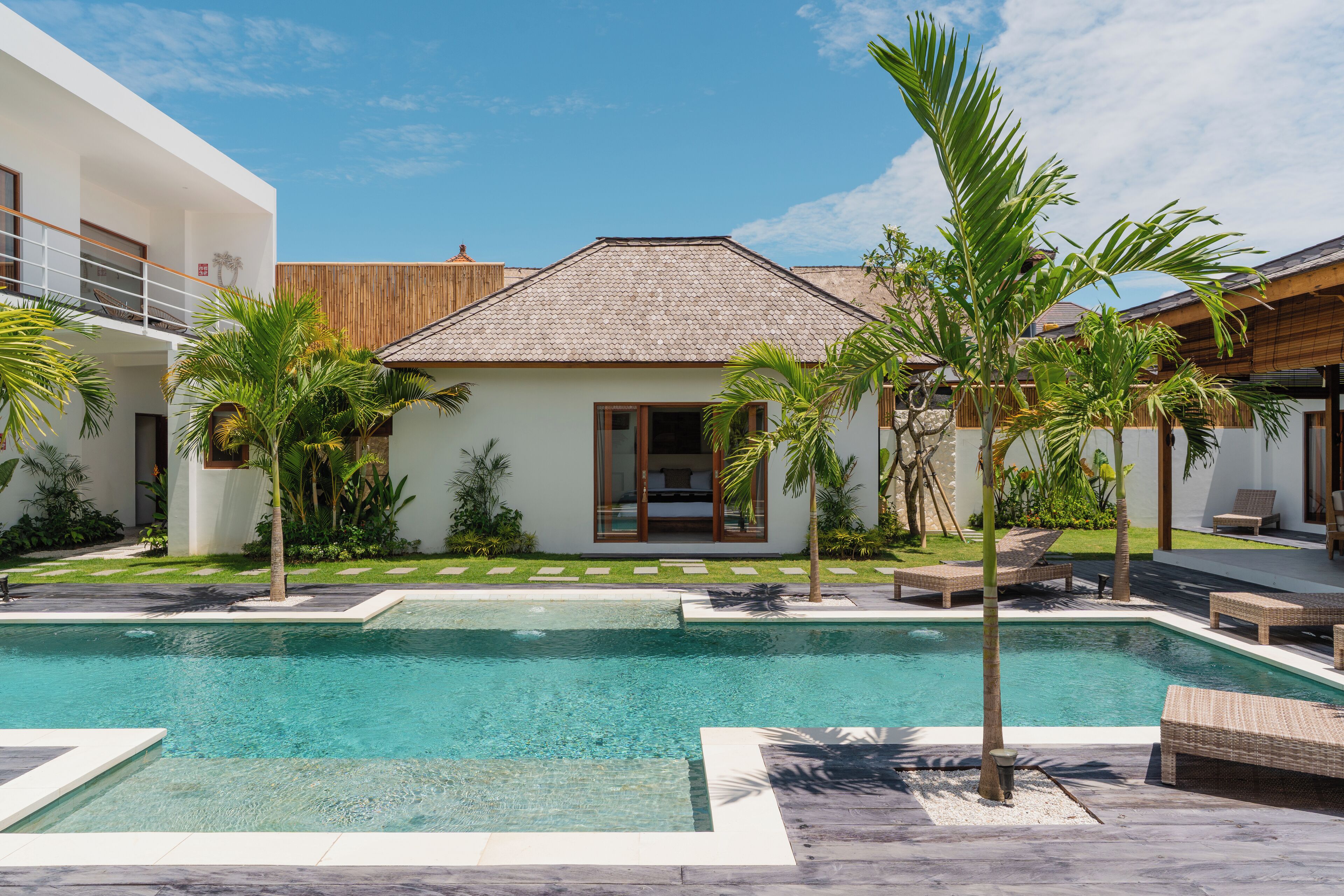 Una piscina al aire libre, sillones reclinables de piscina