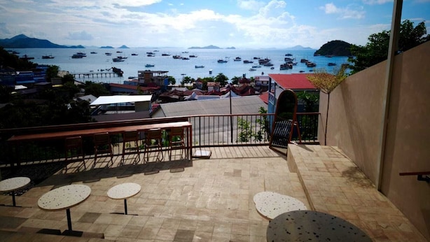 Una terraza con asientos al aire libre y vistas a barcos en el agua.
