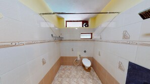 Bañera con ducha, toallas, jabón, shampoo