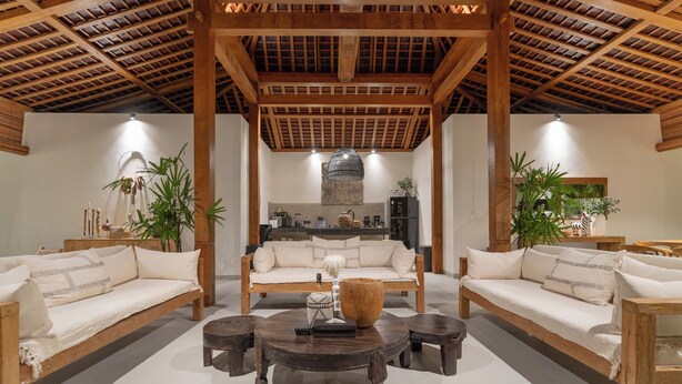 A spacious living area with a wooden ceiling, two sofas, a coffee table, and potted plants. - Villa Nador by Alfred in Bali (Seminyak)